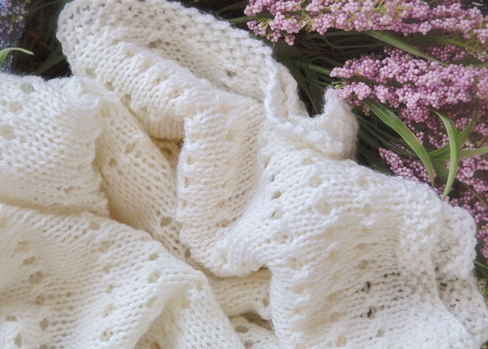 Eyelet Baby Blanket - Each of these baby blanket knitting patterns is suitable for any skill level and is fun to make. The best part is how colorful they all are and how versatile. #BabyBlanketKnittingPatterns #KnitBabyBlankets #FreeKnitPatterns