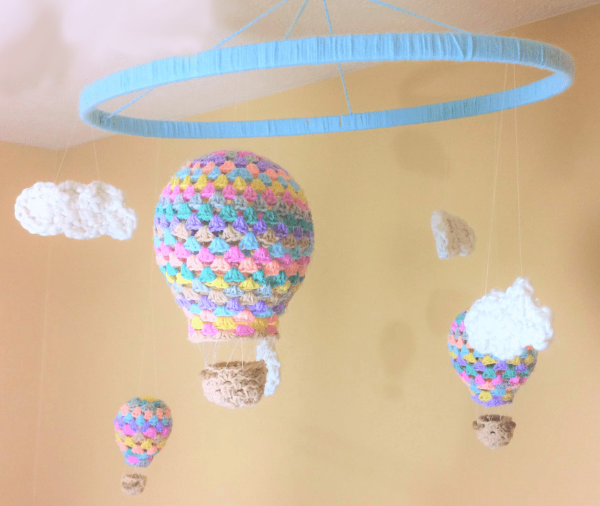 Hot Air Balloon Nursery Mobile - Crochet baby mobiles are colorful, fun and creative. Grab your hook and your favorite type of yarn, and get started on a baby mobile for someone you know. #CrochetBabyMobiles #CrochetPatterns #FreeCrochetPatterns