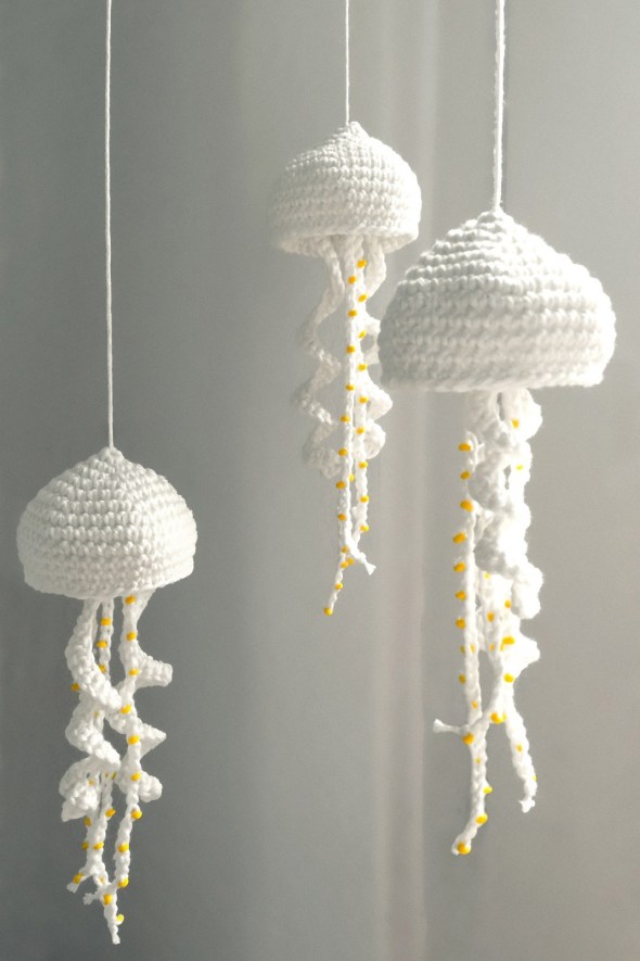 Jellyfish Mobile - Crochet baby mobiles are colorful, fun and creative. Grab your hook and your favorite type of yarn, and get started on a baby mobile for someone you know. #CrochetBabyMobiles #CrochetPatterns #FreeCrochetPatterns