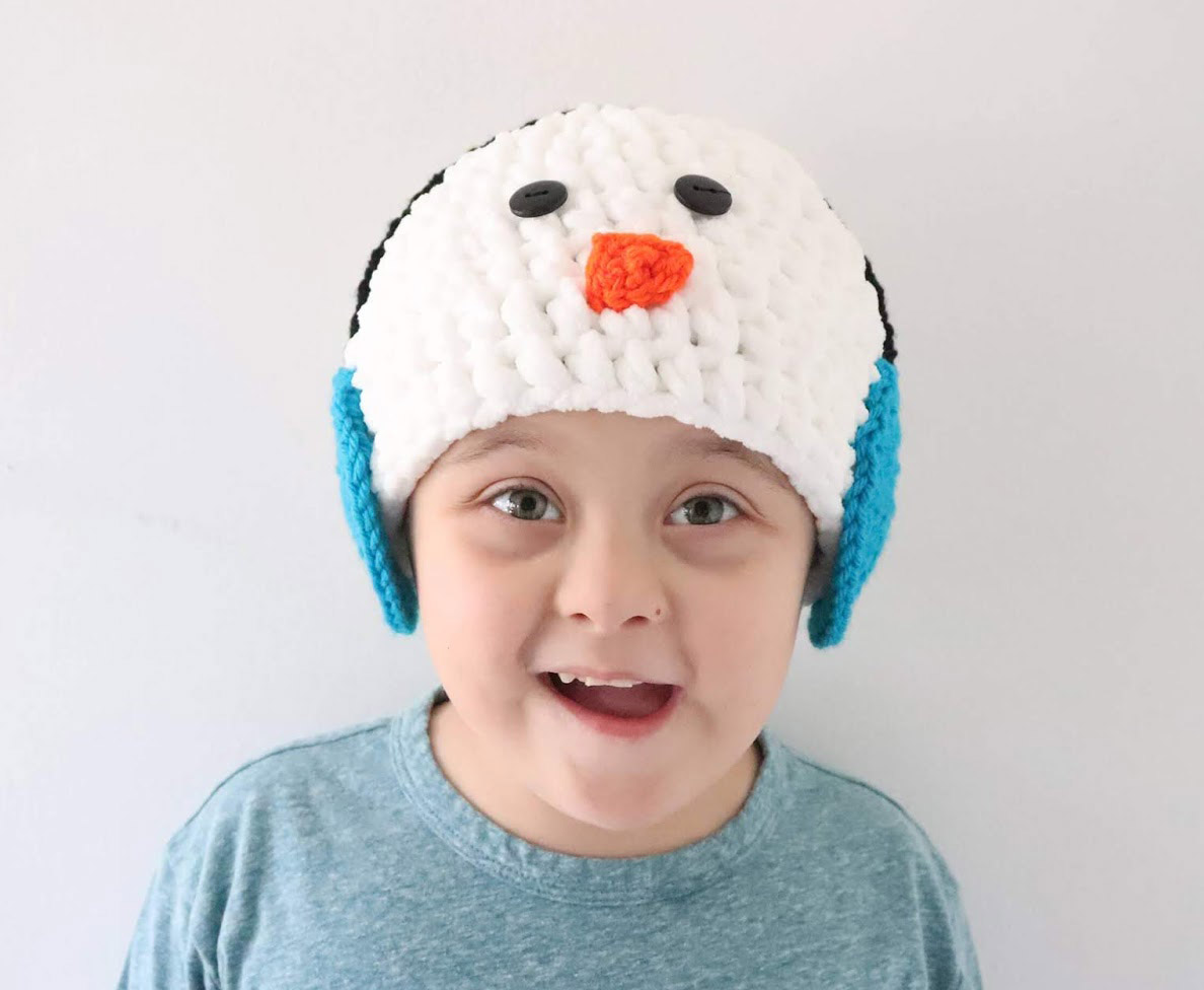 Snowman Hat With Earmuffs - This list of Christmas Crochet hat patterns will supply you with anything from the classics (Santa, Rudolph, Snowman) to fun animals and well-loved characters. #ChristmasCrochetHatPatterns #CrochetHatPatterns #CrochetPatterns