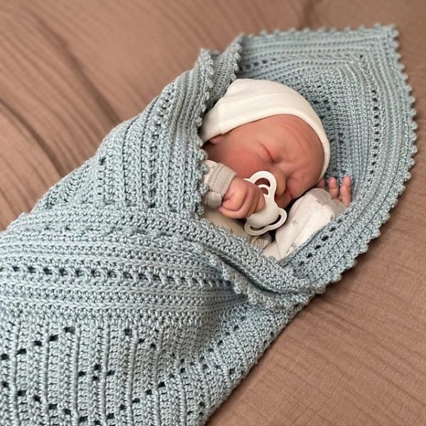 a baby wrapped in a crochet baby blanket