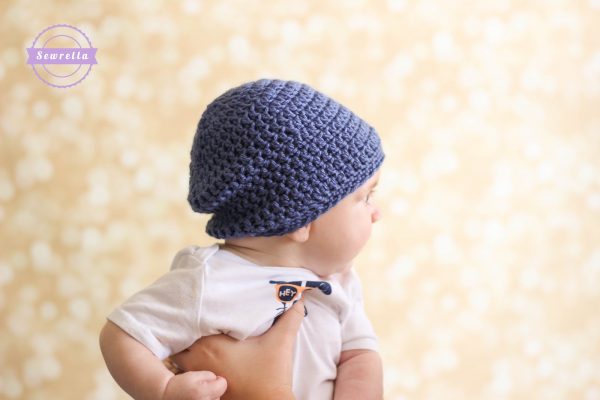a baby wearing a slouchy crochet baby beanie