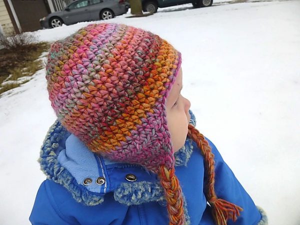 a kid wearing a crochet earflap hat