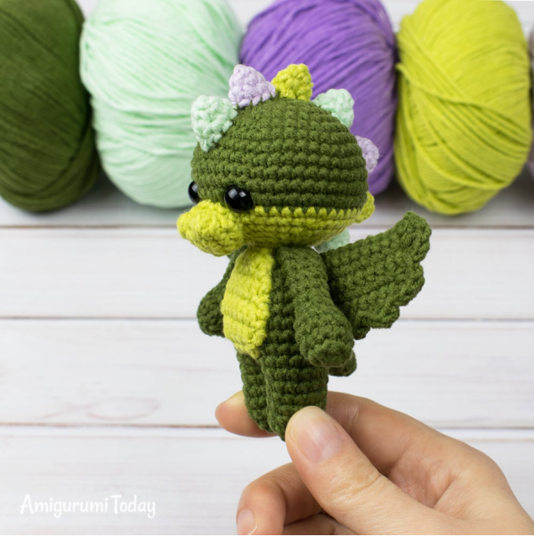 person holding crochet tiny dragon amigurumi