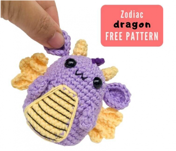 person holding zodiac crochet dragon amigurumi